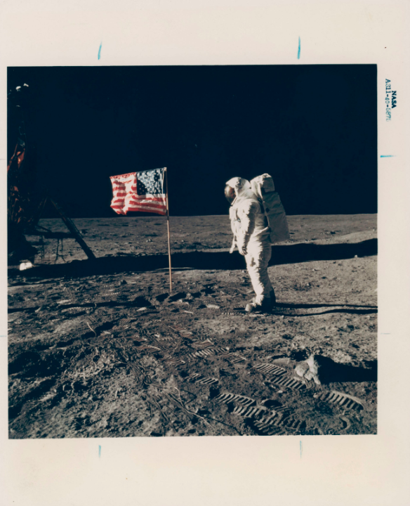 Buzz Aldrin posing for a photograph beside the US flag, July 16-24, 1969