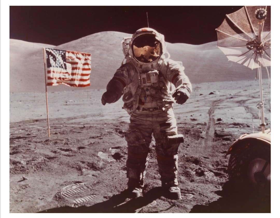 Eugene Cernan on the last human mission on the moon, next to US flag and Lunar Rover